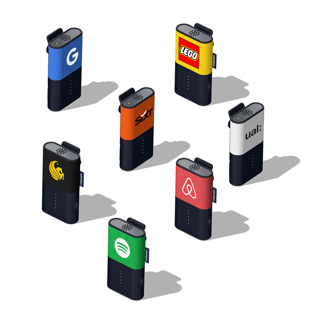 Seven Catchbox Clip presenter microphones placed vertically, showcasing the opportunity to customize the Clip Jackets with company logos and colors.