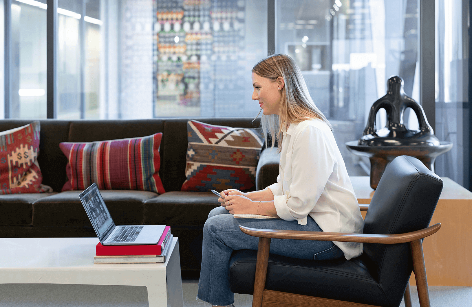 A hybrid worker listening to a meeting from home, where Catchbox Plus is used in the office to capture audio.