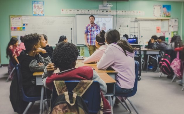 Classroom with students sitting and actively listening to teacher 