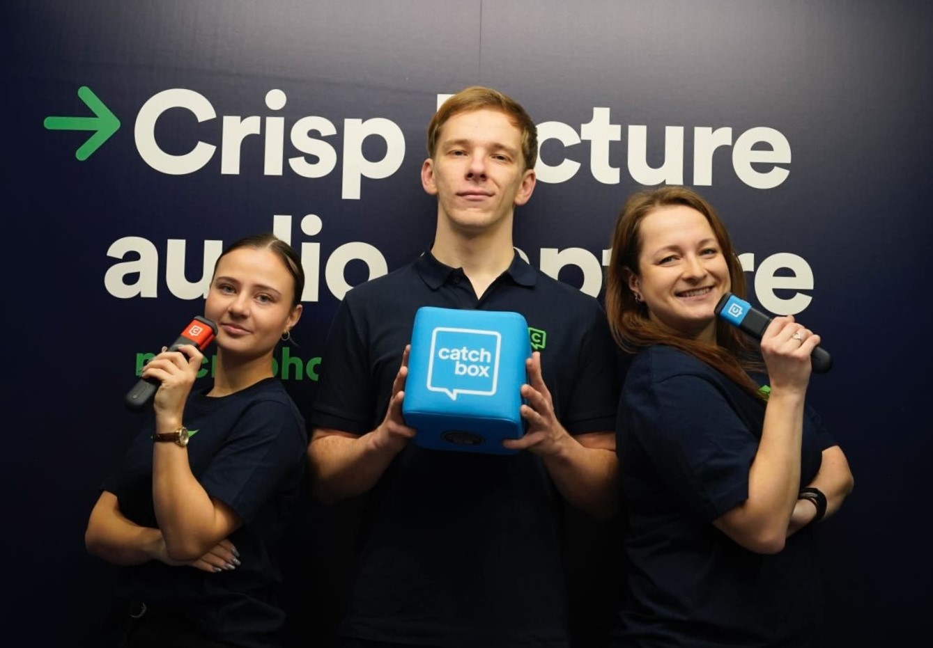 Three Catchbox team members holding Catchbox Plus microphones—Cube, Clip, and Stick—in their hands