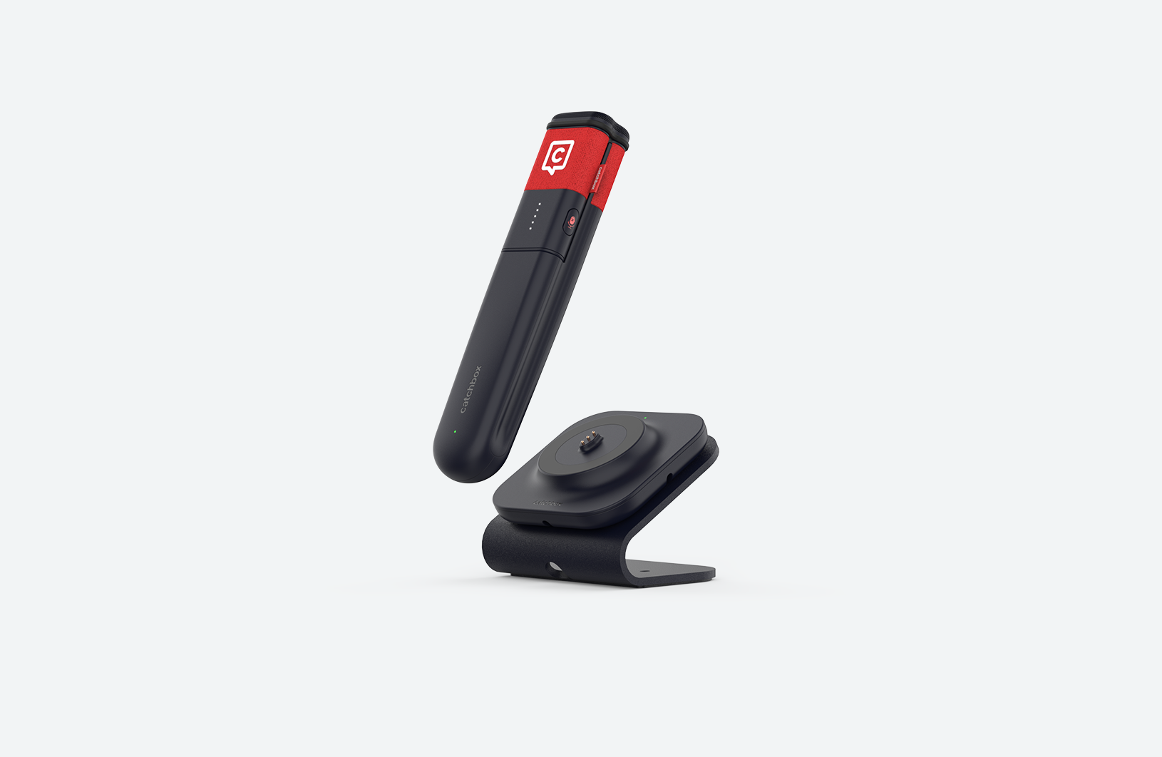 A red Catchbox handheld Stick microphone placed on a Charging Dock, charging wirelessly.